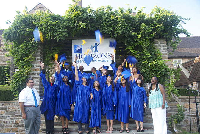 Horizons graduates throwing their caps into the air